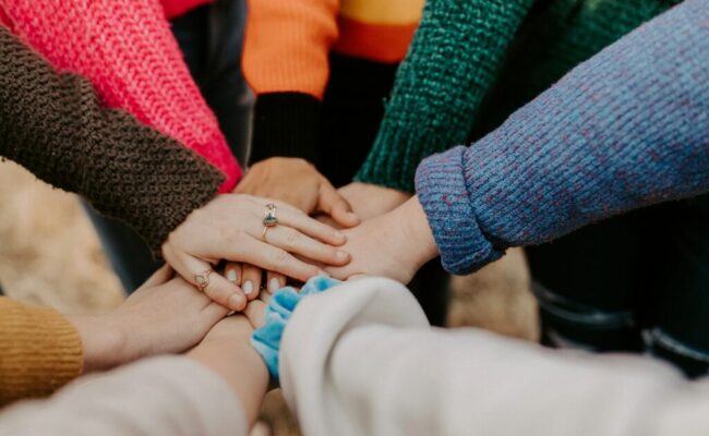 person-in-red-sweater-holding-babys-hand-Zyx1bK9mqmA