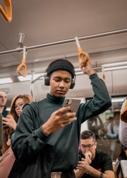 man-in-train-holding-smartphone-oqY09oVTa3k