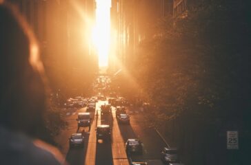 vehicles-passing-between-buildings-during-sunset--K8COreKtUU