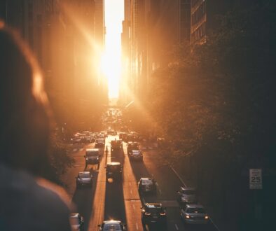 vehicles-passing-between-buildings-during-sunset--K8COreKtUU