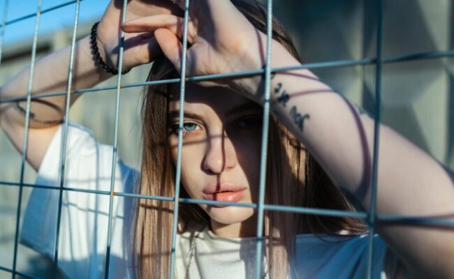 photo-of-woman-leaning-on-screen-fence-2926249/