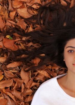 woman-lying-on-ground-with-brown-leaves-98DhcSEWWSg