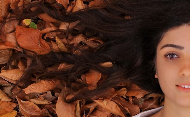 woman-lying-on-ground-with-brown-leaves-98DhcSEWWSg