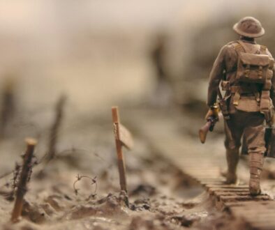 soldier-walking-on-wooden-pathway-surrounded-with-barbwire-selective-focus-photography-qwe8TLRnG8k